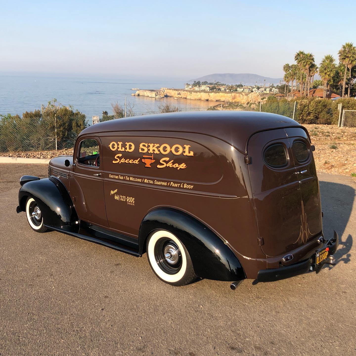 Vintage brown panel van advertising Old Skool Speed Shop Auto Body Shop, parked beside the Pacific Ocean.